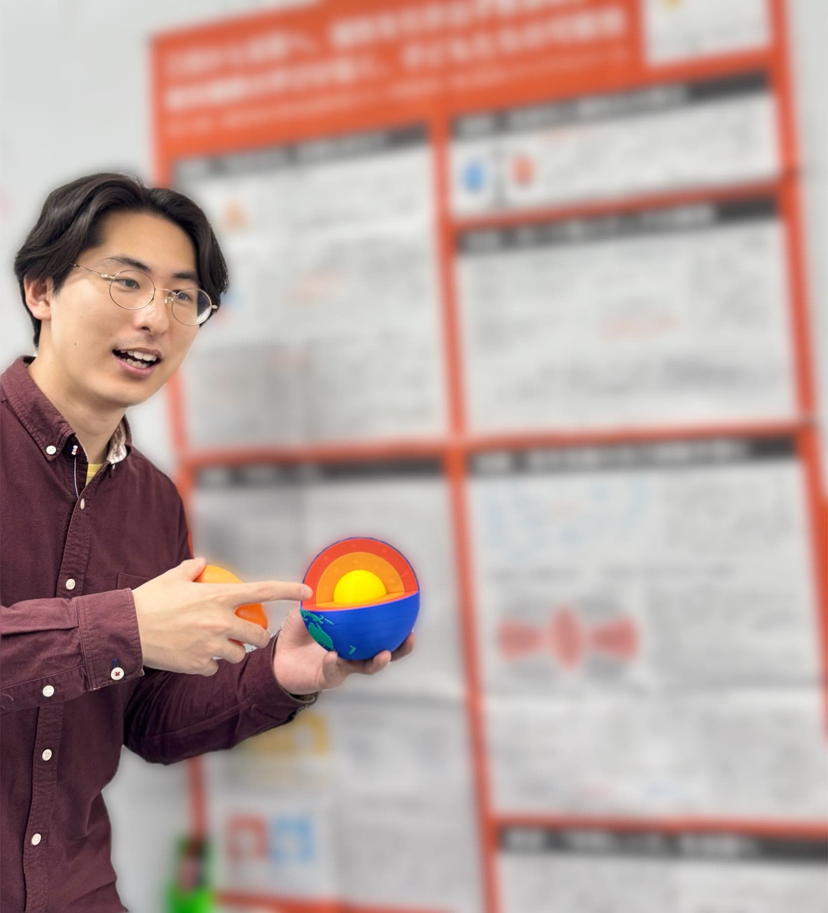 ポスター発表で学問レンズを手に説明する代表